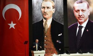 Turkey's PM Recep Tayyip Erdogan addresses the AKP, in front of portraits of himself and Mustafa Kemal Ataturk, the founder of modern Turkey. Critics have accused the PM of creating a cult of personality