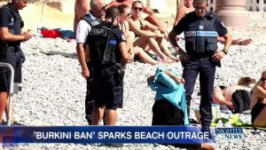 Four policemen in Nice, France, are pictured forcing a woman to remove part of her clothes because her outfit violated the city's "burkini ban," on August 23. They also fined her for the violation