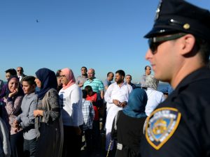 A member of the New York City police department stands guard during a group prayer session for the Muslim holiday Eid al-Adha in the Brooklyn borough of New York City, on August 12, 2016. Photo courtesy of Reuters/Stephanie Keith