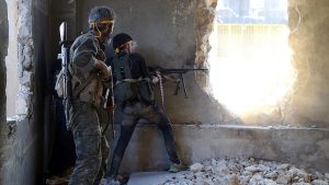 Rebel fighters fire toward regime forces on the southwestern edges of Aleppo